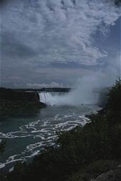 Distant View Of Mist-shrouded Niagara Falls Under A Cloudy Sky. Niagara Falls, Ontario, Canada. (Photo by Todd Gipstein/National Geographic/Getty Images)