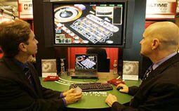 MACAU, CHINA: People look at an online game hosted live from a server in Costa Rica at the 4th International Gaming and Entertainment Expo in Macau 28 April 2005. Macau has recently seen a huge influx of casinos that have awakened with a jolt the once ailing economy.